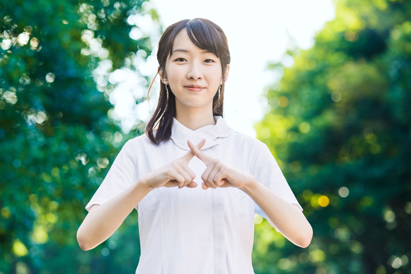 バツ印を作る女性